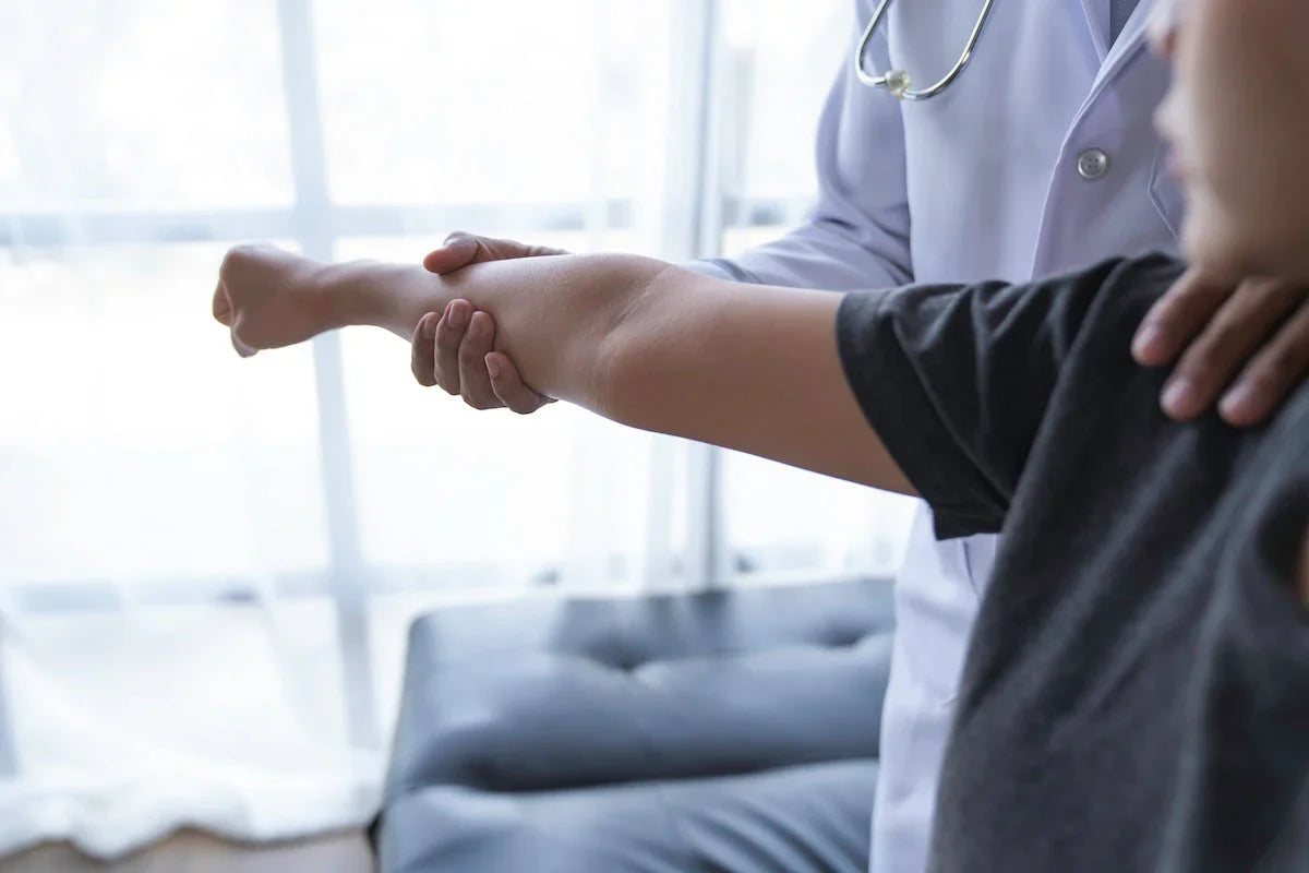 Arzt untersucht den Ellenbogen eines Patienten – Symbol für Gelenkgesundheit und medizinische Beratung.